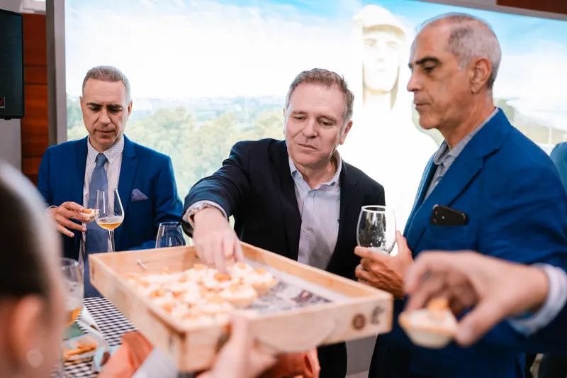 Waiters passing wooden trays of tartlets among the guests